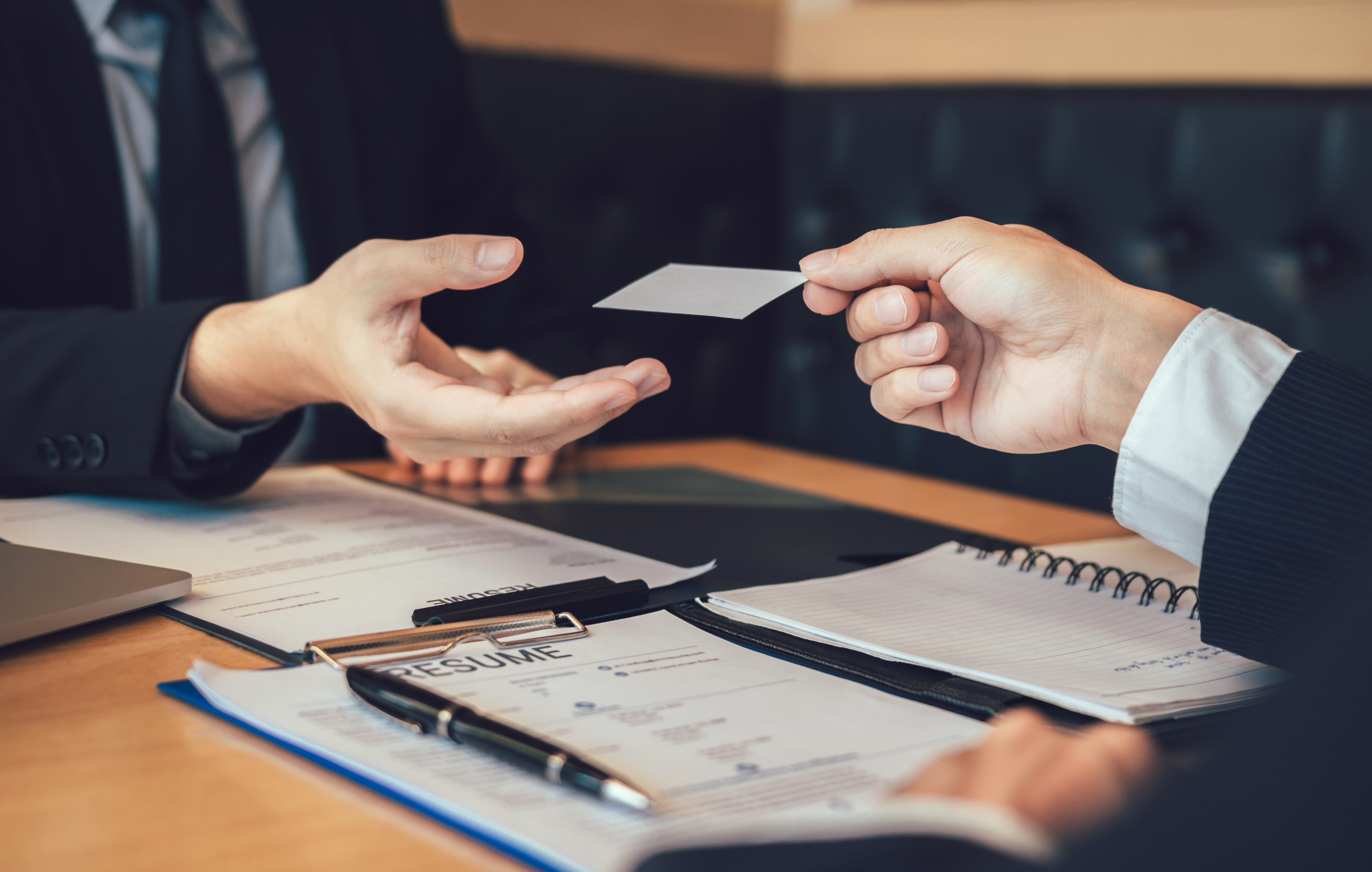 Employees submit business cards to job interviewers and interested in joining him contact